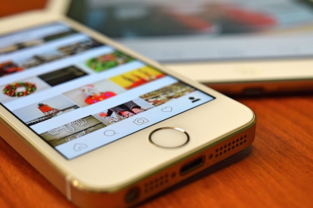 A close-up view of a smartphone displaying the Instagram app on a wooden surface.