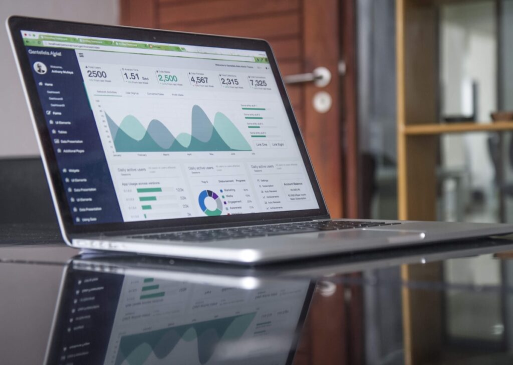 Laptop on desk displaying a marketing analytics dashboard with conversion metrics and charts
