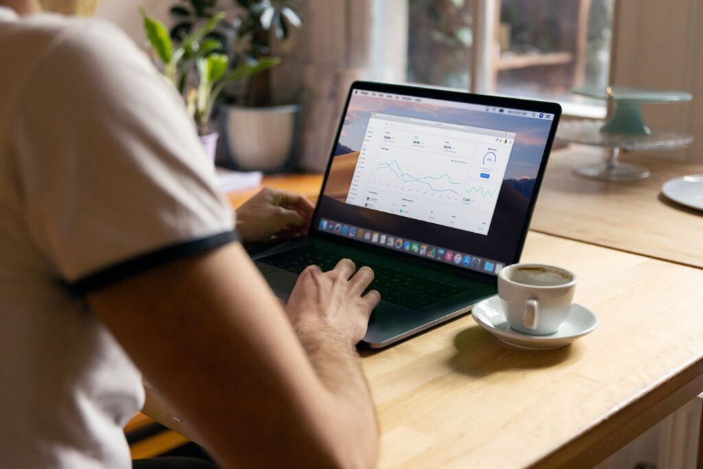 Small business owner reviewing an analytics dashboard on a laptop in a home office